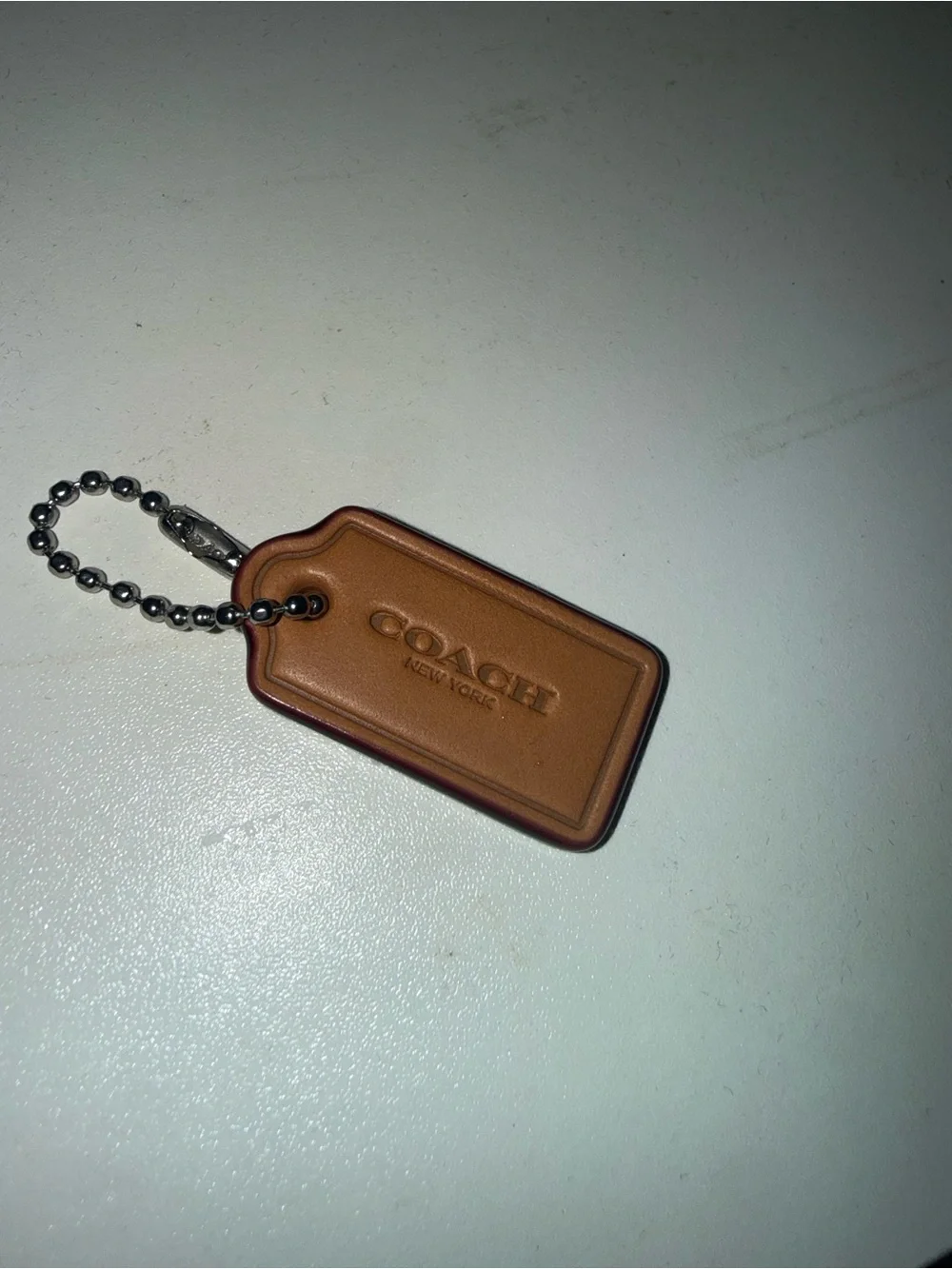 Coach Brown Leather hang Tag from red denim nolita bag